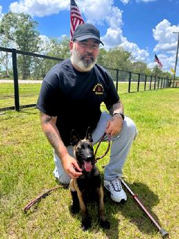 Cedrik Merlet, Honorary Training Director, with Major, a young male Malinois pup.